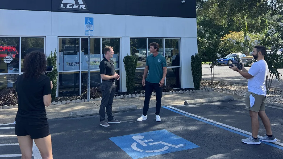 Two people talking outside a vehicle-personalization shop